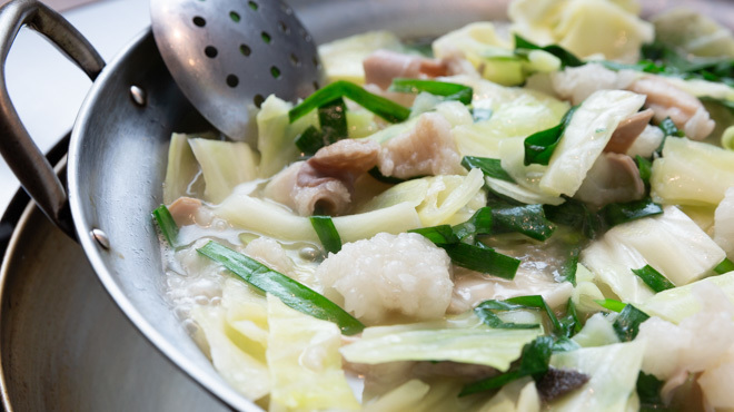 餃子の皮と一緒に自家製酢醤油につけていただく「もつ幸」ならではのもつ鍋