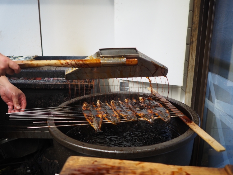 焼き上げられた鰻に、素早くたっぷり秘伝のタレをまとわせる