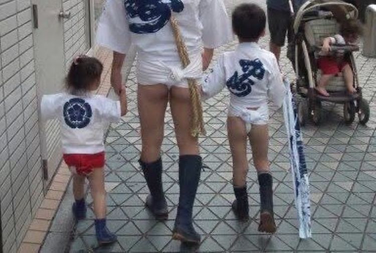 誇らしそうに父親と追い山笠の舞台へと向かう子どもたち