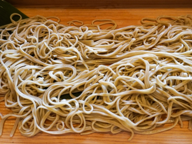 水を受けてきらきらと光り輝く、茹でたての蕎麦 