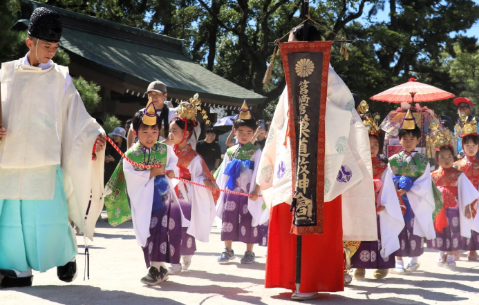 放生会の最終日に執り行われる稚児行列で神職や巫女に先導される子どもたち