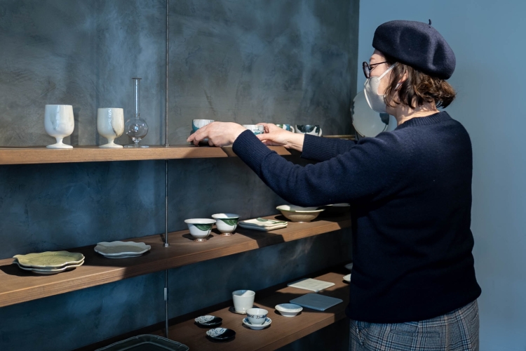 形や質感がさまざまな個性ある器たちを丁寧に並べていく鶴田さん